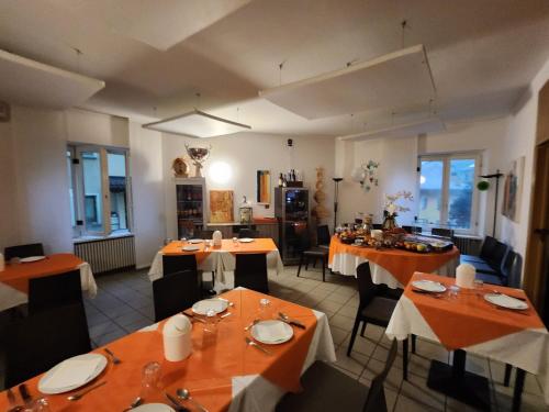 un restaurante con mesas y sillas con manteles naranjas en Hotel Ristorante Camoghe, en Isone
