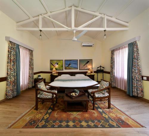 a large room with a table and two chairs at Neemrana's Glasshouse on the Ganges in Rishīkesh