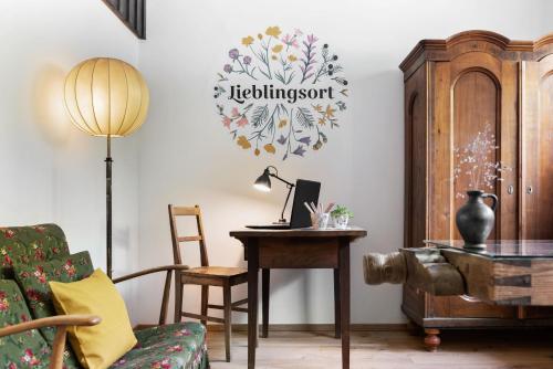 a living room with a desk and a table with a lamp at Sloho Bergurlaub in Hohentauern