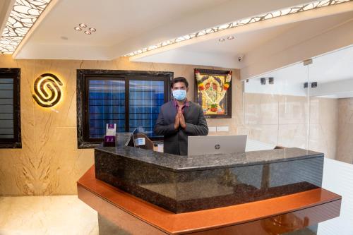 a man wearing a mask in a hotel lobby at Hotel Grand Sabarees in Madurai