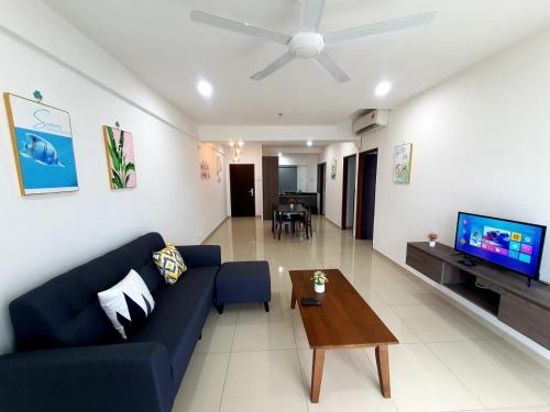 a living room with a blue couch and a tv at LOVELY 2ROOM SUITE6PAX@SKY CONDO JURU SENTRAL in Bukit Mertajam