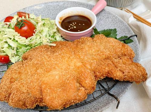 einen Teller mit Hühnchen, Salat und Soße in der Unterkunft Hotel Ristorante Camoghe in Isone