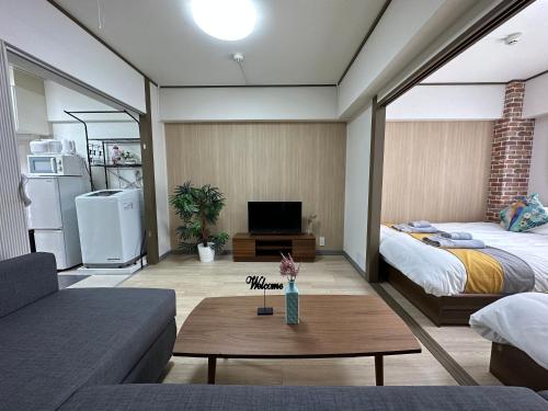 a living room with a bed and a couch at nestay apartment tokyo otsuka in Tokyo