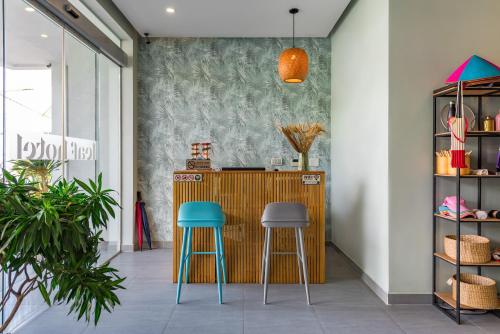 a bar with two blue stools in a room at Leaf Hotel Phu Quoc in Phu Quoc