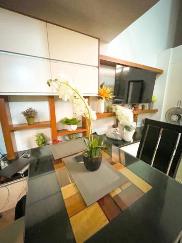 Lovely 1BR Loft in BGC up to 6pax في مانيلا: غرفة طعام مع طاولة عليها نبات