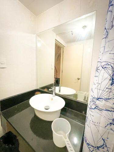 a bathroom with a sink and a mirror at Lovely 1BR Loft in BGC up to 6pax in Manila