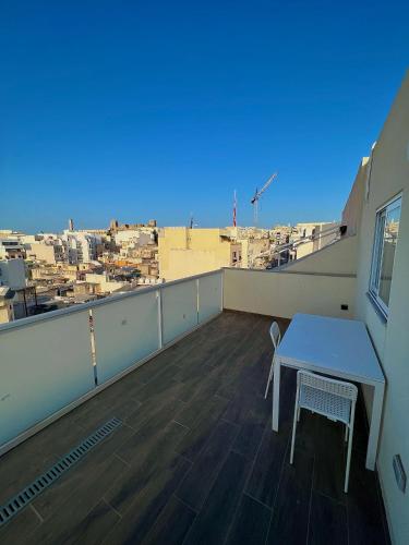 a table and chairs on a balcony with a view at Luxury Penthouse in Tal-Pietà