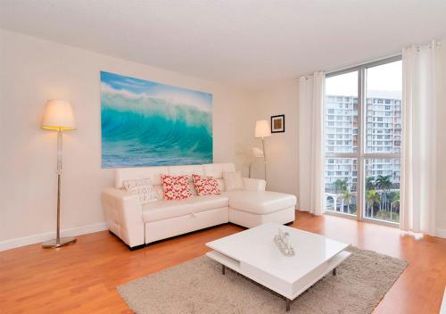 een woonkamer met een witte bank en een tafel bij Stunning Beach Apartment by Miami Te Espera - HOLLYWOOD 9W in Hollywood