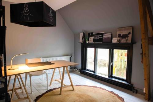 een eetkamer met een tafel en een raam bij Bijzonder stadshuis met diepe moderne tuin. in Alphen aan den Rijn