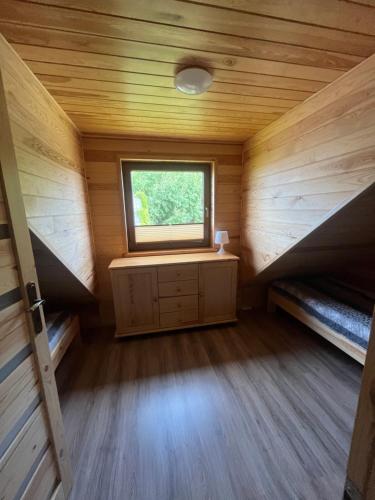 a small room with two bunk beds and a window at Rajski Zakątek in Chłopy