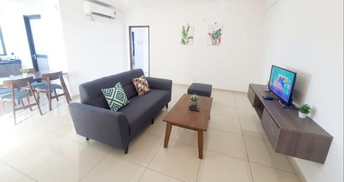 a living room with a couch and a table with a television at LOVELY 2ROOM SUITE6PAX@SKY CONDO JURU SENTRAL in Bukit Mertajam
