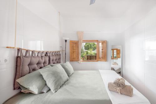 Un dormitorio blanco con una cama grande y una ventana en La Bombonera en Catadau