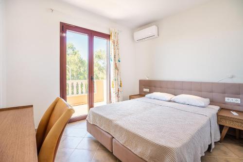 sypialnia z łóżkiem, stołem i oknem w obiekcie Sky Hills w mieście Psinthos