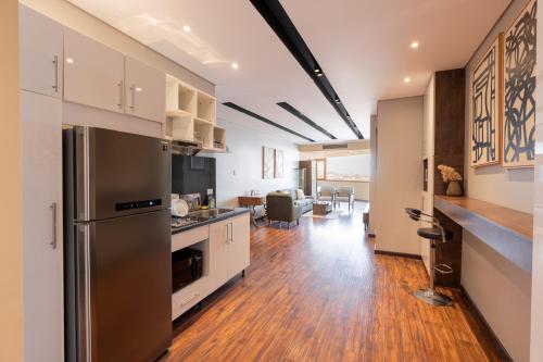 a kitchen with a stainless steel refrigerator and a living room at Zamalek Serviced Apartments by Brassbell in Cairo