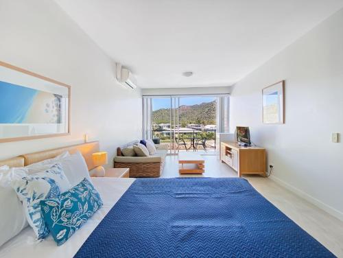 ein Schlafzimmer mit einem großen Bett mit einer blauen Decke in der Unterkunft Blue on Blue Studio Room 1322 in Nelly Bay