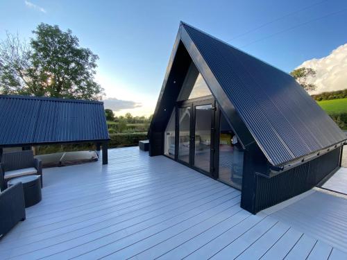 a house with a black roof with a deck at The Hut 45 in Newry