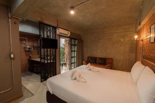 a bedroom with a bed with two stuffed animals on it at The Old Inn in Udon Thani