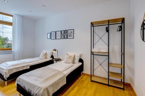 a room with two beds and a glass cabinet at Kaza Guesthouse, centrally located 2 & 3 bedroom Apartments in Augsburg in Augsburg