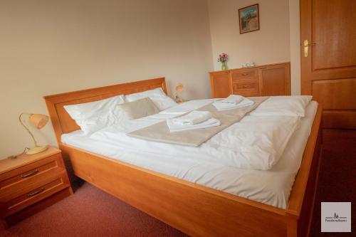 a bedroom with a large bed with two towels on it at Penzión na Bezovci in Nová Lehota