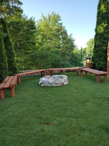 a group of wooden benches in a park at Penzión na Bezovci in Nová Lehota