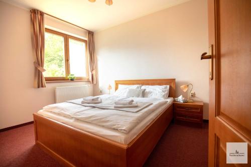 1 dormitorio con 1 cama grande y ventana en Penzión na Bezovci en Nová Lehota