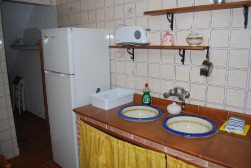 een aanrecht met 2 wastafels en een koelkast bij El rinconcito in Fuenteheridos
