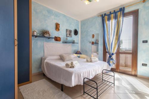 ein Schlafzimmer mit blauen Wänden und ein Bett mit Handtüchern drauf in der Unterkunft Il Risveglio in Codrongianos