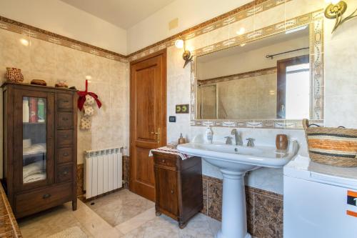 ein Bad mit einem Waschbecken und einem Spiegel in der Unterkunft Il Risveglio in Codrongianos