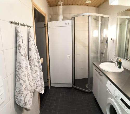 uma casa de banho com um chuveiro e um lavatório. em Laatuhuoneisto Saimaa näkymällä- Luxury apartment by lake Saimaa em Imatra