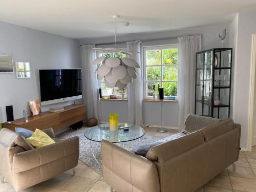 a living room with two couches and a tv at Ferienwohnung Jardin im Kunsthaus in Greifenberg