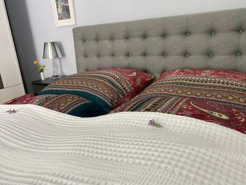 a bed with a white comforter and two pillows at Ferienwohnung Jardin im Kunsthaus in Greifenberg