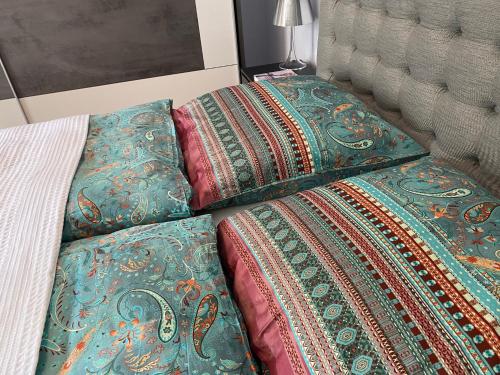 a bed with three pillows on it next to a bed at Ferienwohnung Jardin im Kunsthaus in Greifenberg