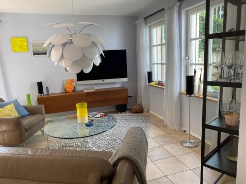 a living room with a couch and a tv at Ferienwohnung Jardin im Kunsthaus in Greifenberg