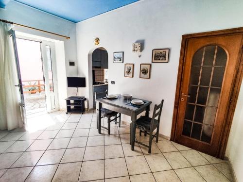 a dining room with a table and chairs and a door at Casina Tecla in Cavo