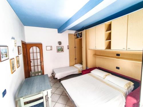 a room with two beds and a blue ceiling at Casina Tecla in Cavo