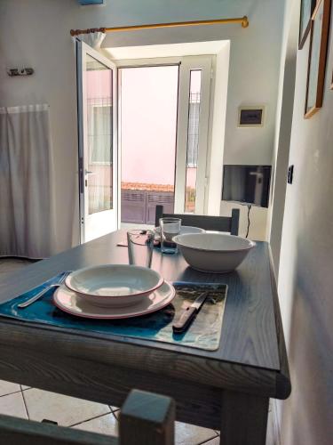 a table with plates and bowls on top of it at Casina Tecla in Cavo