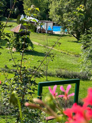 a mirror in a garden with pink flowers in the foreground at Imanje Lotus Garden in Šabac