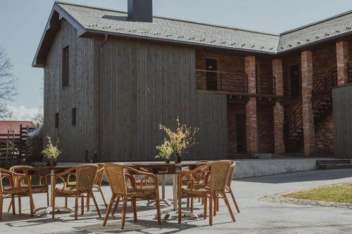 a table and chairs in front of a building at Zīles - Atpūtas komplekss in Jēkabpils