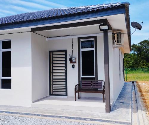 a small white house with a bench in it at Mukmin 2 Stay in Melaka