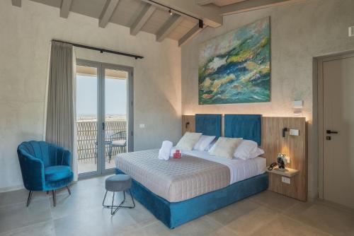 アグリジェントにあるTerreforti Luxury Villageのベッドルーム1室(ベッド1台、青い椅子付)
