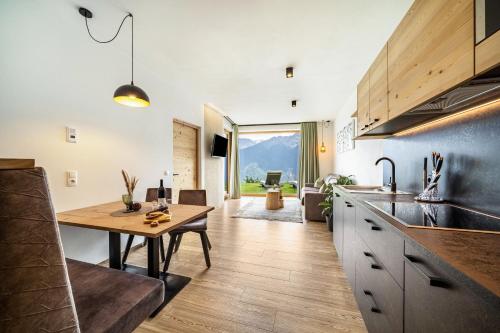 a kitchen with a table and a dining room at Paflur Lodges Lärchenduft in Lasa