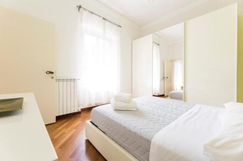 a white bedroom with a large bed and a window at Bernardo House by Holiday Home 24 in Genova