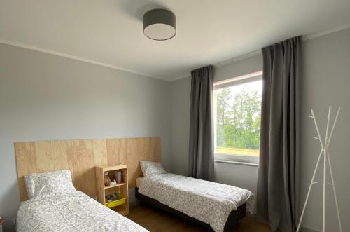 a bedroom with two beds and a window at Apartamenty Spalona Sport in Spalona