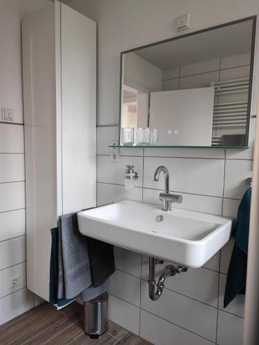 a bathroom with a white sink and a mirror at Muhrbach in Ottersweier