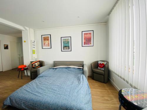 une chambre avec un lit et deux chaises dans l'établissement La Capsule de l’Impasse, à Limoges