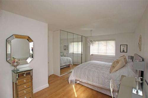 a white bedroom with a bed and a mirror at Large & Spacious 5 Bedroom, 3.5 Bathroom House in Southampton