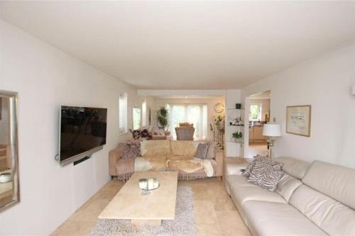 a white living room with a couch and a tv at Large & Spacious 5 Bedroom, 3.5 Bathroom House in Southampton