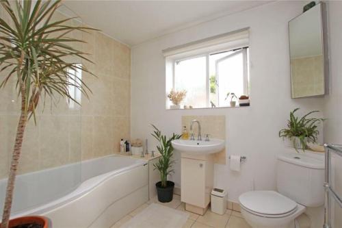 a bathroom with a tub and a toilet and a sink at Large & Spacious 5 Bedroom, 3.5 Bathroom House in Southampton
