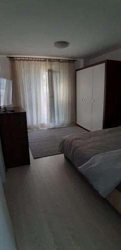 1 dormitorio con cama y ventana grande en apartament, en Floreşti