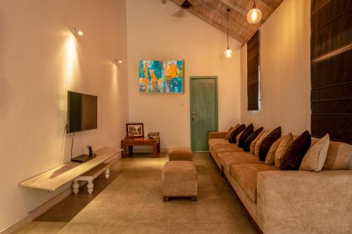 a living room with a couch and a tv at Astig Villa - Negombo in Negombo